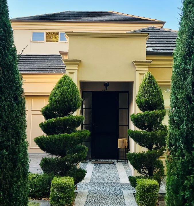 Professional Hedge Trimming & Pruning | Garden Managers Australia A uniformed Garden Managers arborist sculpts a dense lilly-pilly hedge with a cordless pole-trimmer, while ground sheets catch every clipping for a spotless finish.